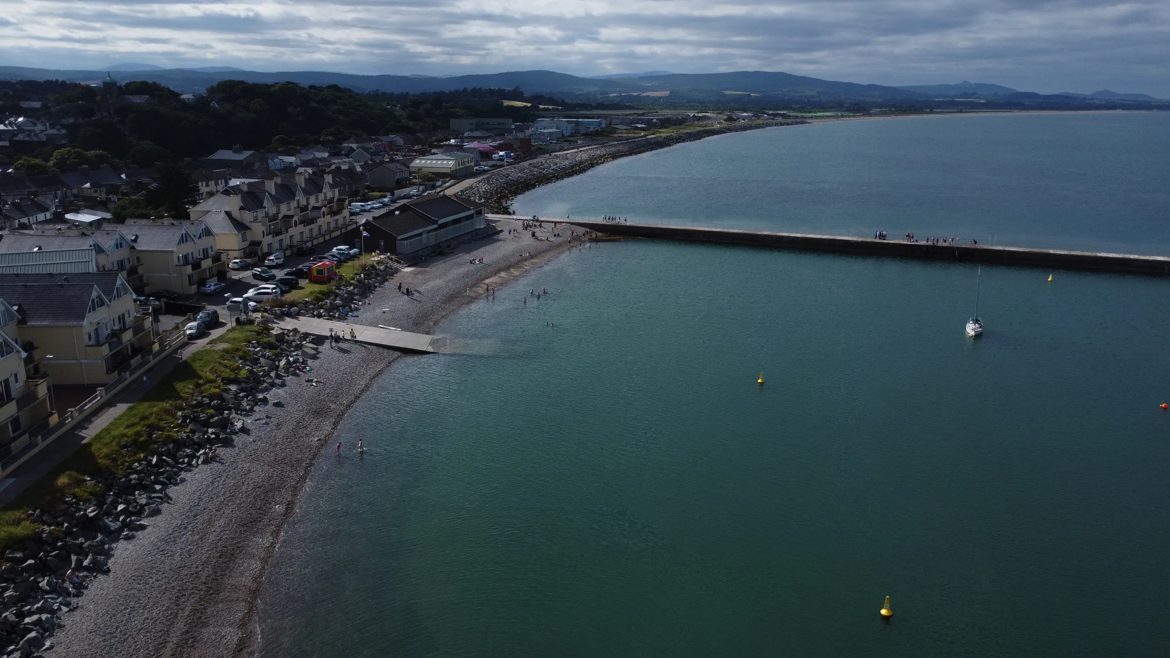 Swimmers in the bay beside the pier seen from above