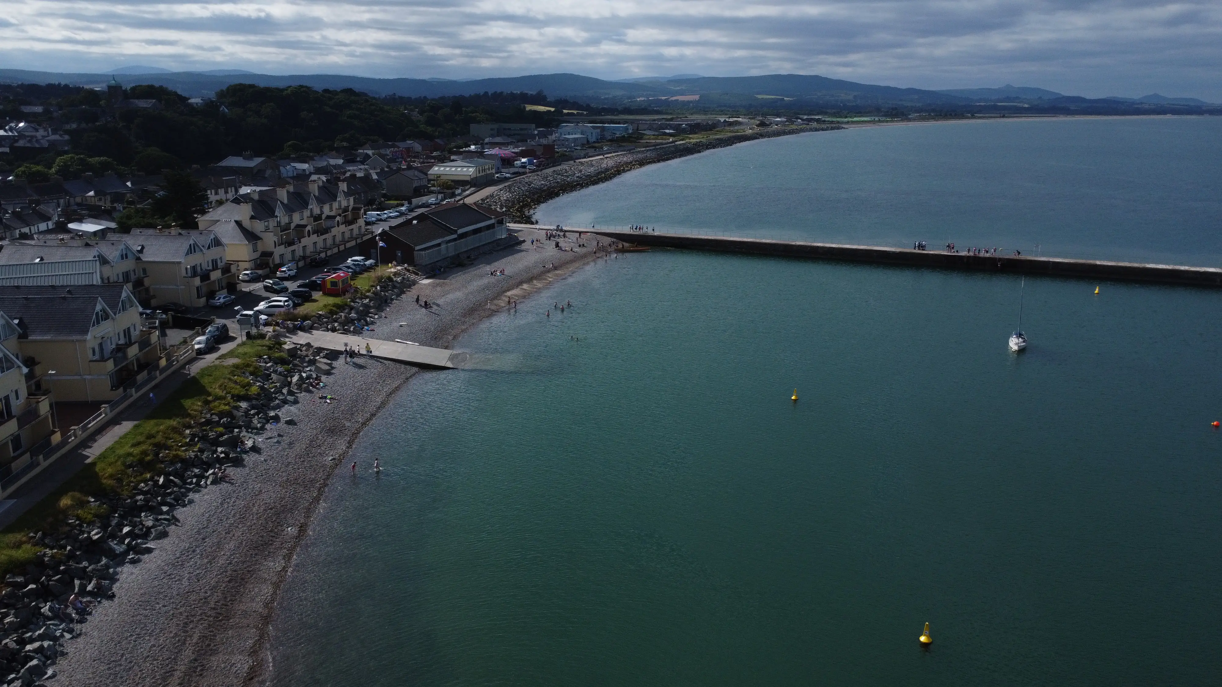 Swimmers in the bay beside the pier seen from above