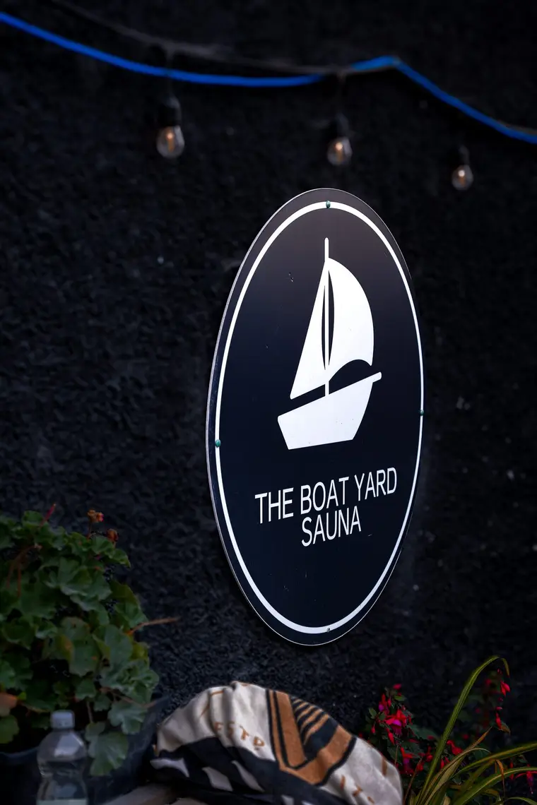 The Boat Yard Sauna sign lit by festoon lights