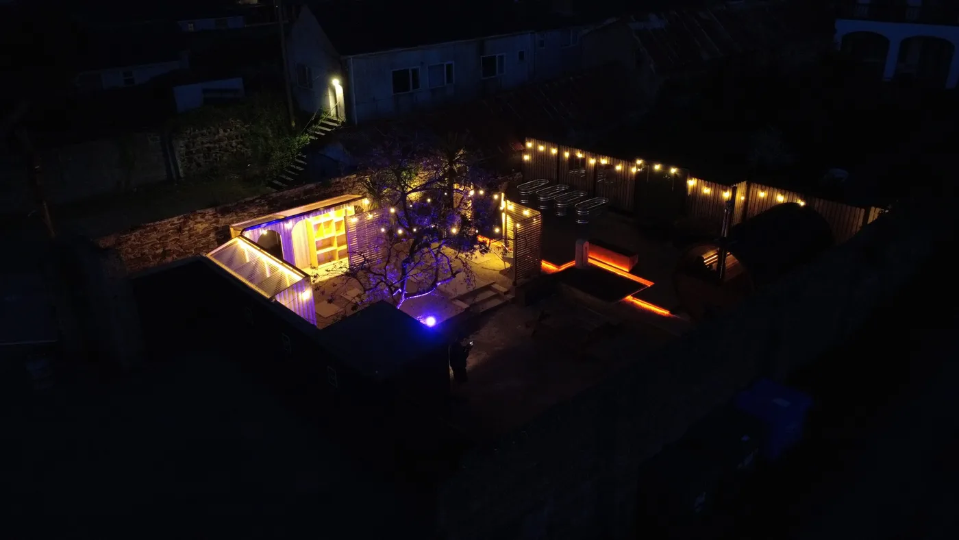 Sauna courtyard lit at night with people relaxing outside