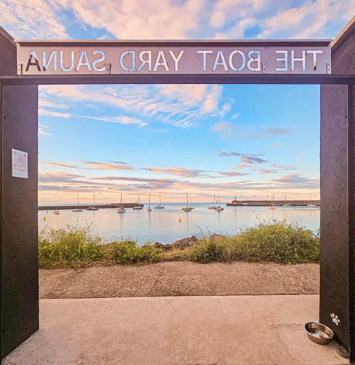 The sauna gate at the harbour framing moored boats at early morning
