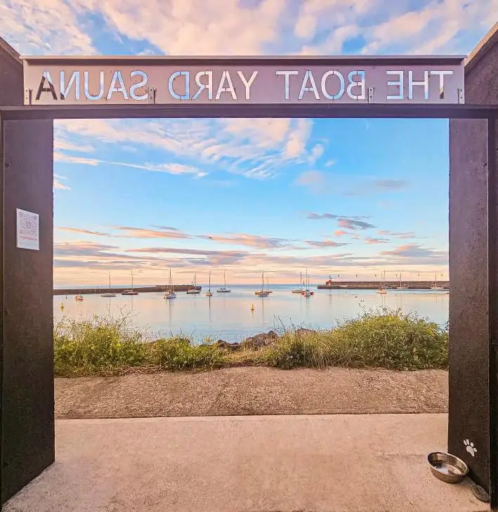The sauna gate at the harbour framing moored boats at early morning