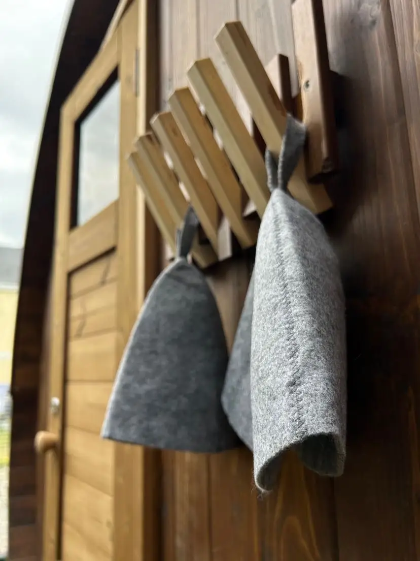 Wool sauna hats hanging on the cedar door