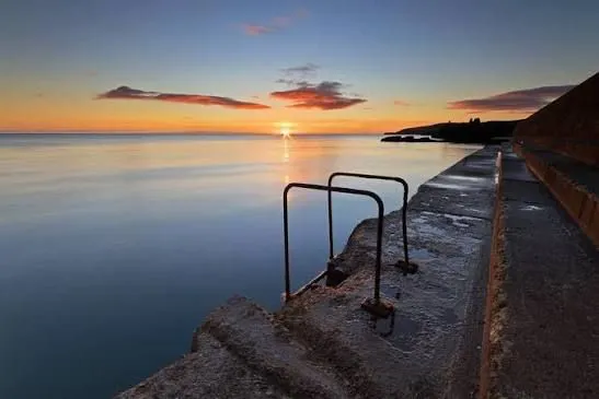 Steps into the sea at sunrise on a warm summer morning