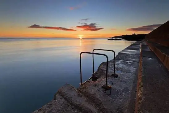 Steps into the sea at sunrise on a warm summer morning